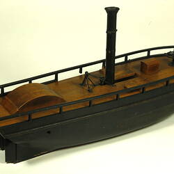 Three quarter view of wooden paddle steamer model.