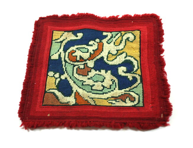 Patterned toy carpet with red border.