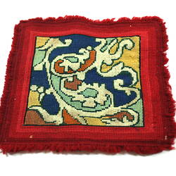 Patterned toy carpet with red border.
