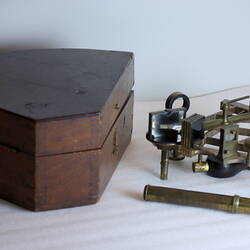 Scientific instrument next to wooden box.