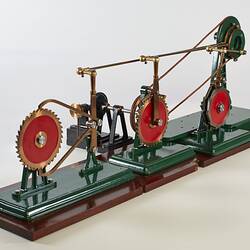 Metal model with green painted frame with metal circular cog shape.
