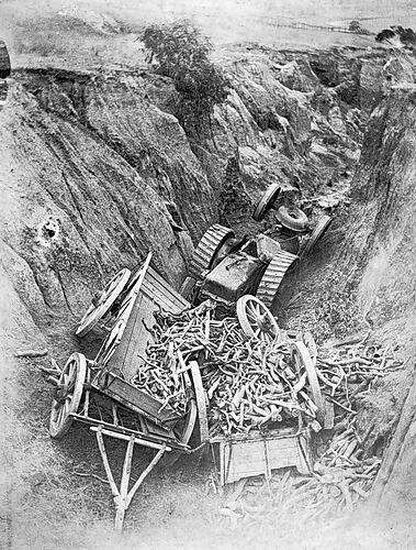 [A tractor and cart wrecked after falling into a deep gully, Victoria, about 1910.]