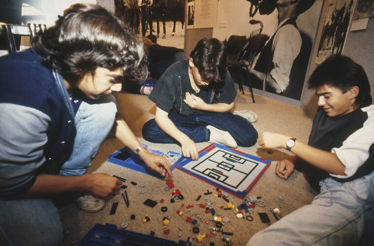 A group of students sitting on the floor playing with Lego.