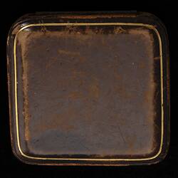 Closed square case with gold border.