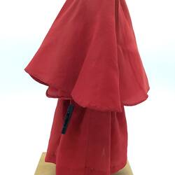 A doll dressed in a red gown and long head scarf