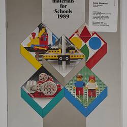 Front cover with five LEGO scenes. Text above. Business card stapled top right corner.