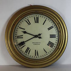 Circular wooden clock painted gold with white face.