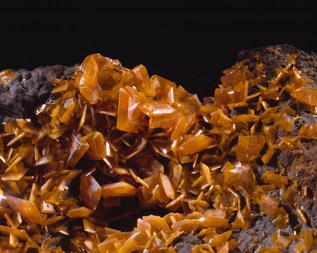 Mass of thin orange-brown crystals.