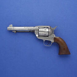 Metal revolver with wooden handle.