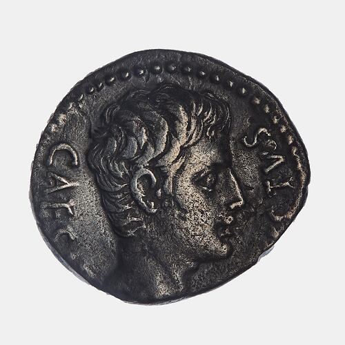 Irregular round coin with male head facing right.