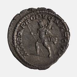 Man advancing left holding a  spear in his right hand, a trophy in his left arm. Text around.