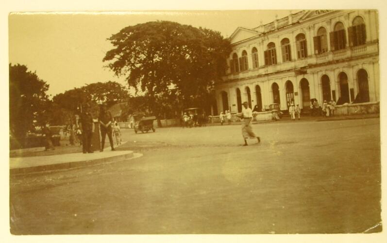 People, cars and horse-drawn cart on street in Colombo.