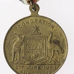 Round medal with Australian coat of arms and text, with red, white and blue ribbon attached.
