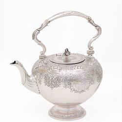 Ornate silver teapot.