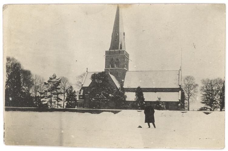 Man in snowy landscape with church building behind.