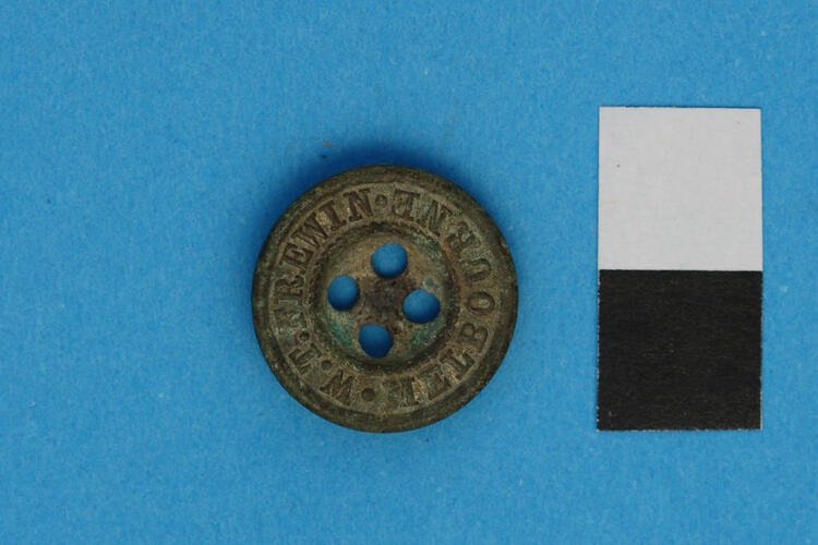 Copper alloy button embossed with some words.