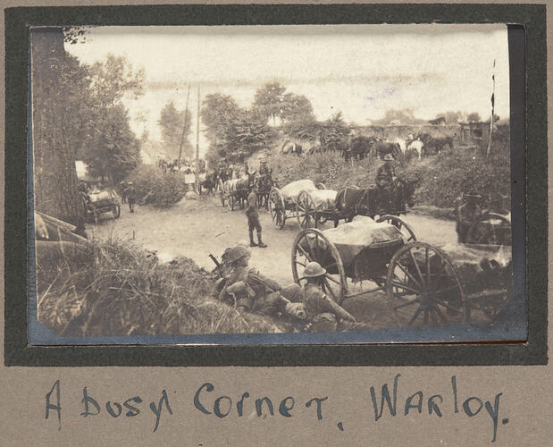Traffic scene with servicemen and horse drawn carts surrounded by bushland.