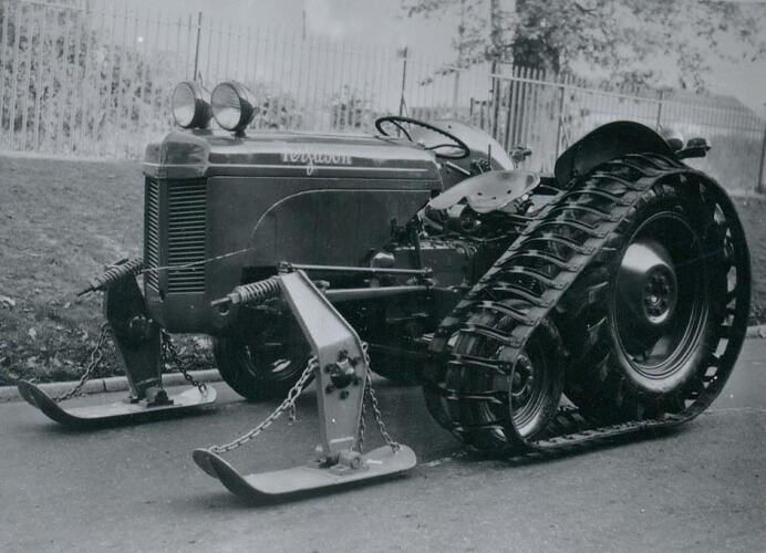 Left side of tractor fitted with half tracks and front snow shoes.