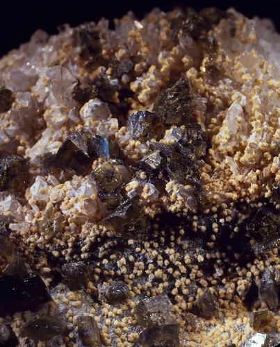 Chunky crystals covered by speckles of yellowish mineral.