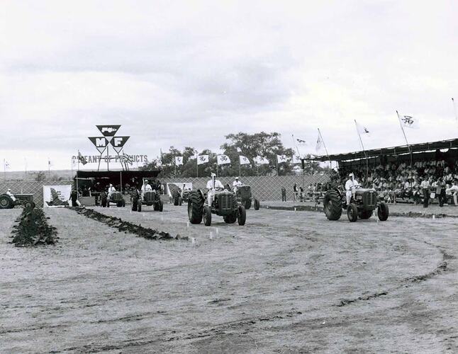 Tractors on display in front of grandstand.