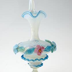 Blue blown-glass ewer, spiral fluted neck, serpentine handle, flattened bulbous body layered with pink, blue, green flowers and leaves.