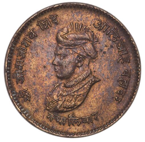 Round brown coin with profile of man facing left. Sanskrit characters around edge.