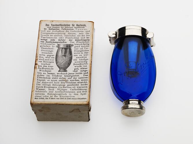 Blue glass egg shaped vessel. Silver hinged lid, internal funnel and base. Printed text, image on card box.