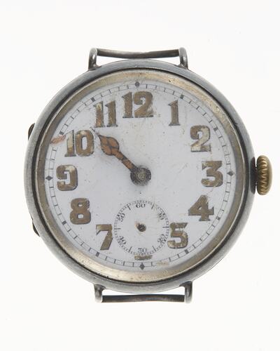Watch face, scratched white enamel, brown numbers. Metal case, dial. Missing strap. Has hour hand. Minute, sec