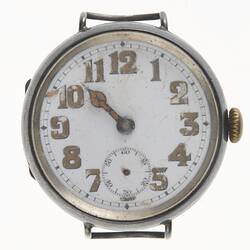 Watch face, scratched white enamel, brown numbers. Metal case, dial. Missing strap. Has hour hand. Minute, sec