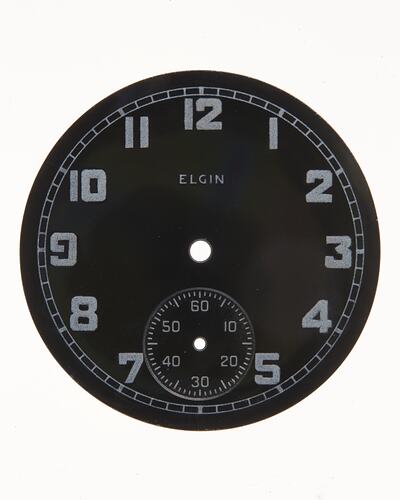 Round dark watch dial with light coloured numbers and markings.