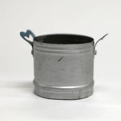 Side view of tiny aluminium pot with handles.