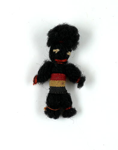 Front of tiny black wool doll.
