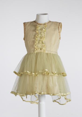 Yellow child's dress, sleeveless, layered lace skirt, gold trim.