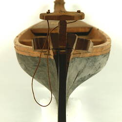 Wooden boat with black hull, rear view.