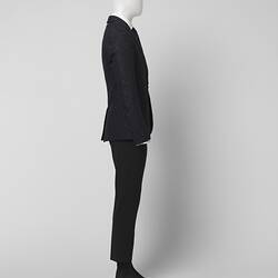Right profile view of black suit made of textured black and grey wool blend fabric, Two pockets.