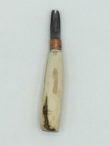 Knife with partially carved wooden handle and small blade.
