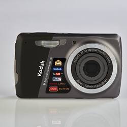 Black and grey camera with metal trim on back, sides and around the lens.