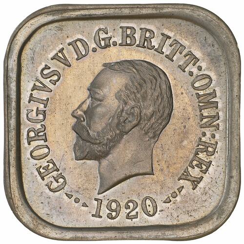 Square silver coin with rounded corners. Bearded male head facing left, text around.