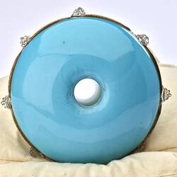 Round base of pale blue opaque glass vase. Hole in centre.