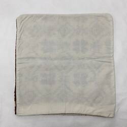 White back of square cushion cover.