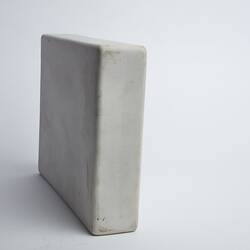 Back of narrow white rectangular ceramic container.