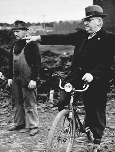 WELL KNOWN IDENTITIES AT WORK REG BARCLAY (RIGHT) FOREMAN OF THE RECLAMATION DEPARTMENT, DIRECTS HIS LEADING HAND, BERT FLOWERS, REGARDING THE DISPOSAL OF A HEAP OF SCRAP IRON. REG AND HIS FAMOUS BICYCLE ARE A FAMILIAR SIGHT ABOUT THE FACTORY. 'SUNSHINE R