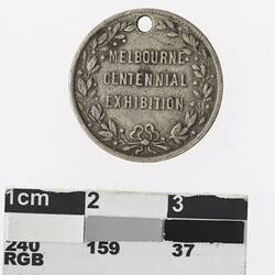 Round medal with central text framed by wreath.