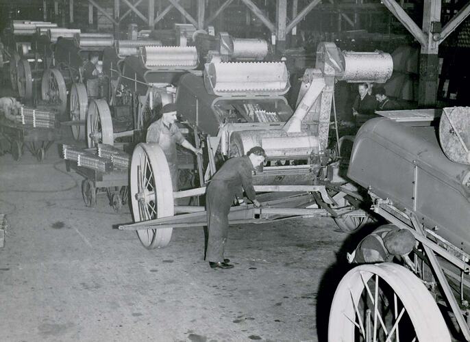 Men working on  factory assembly line making Header Harvesters.