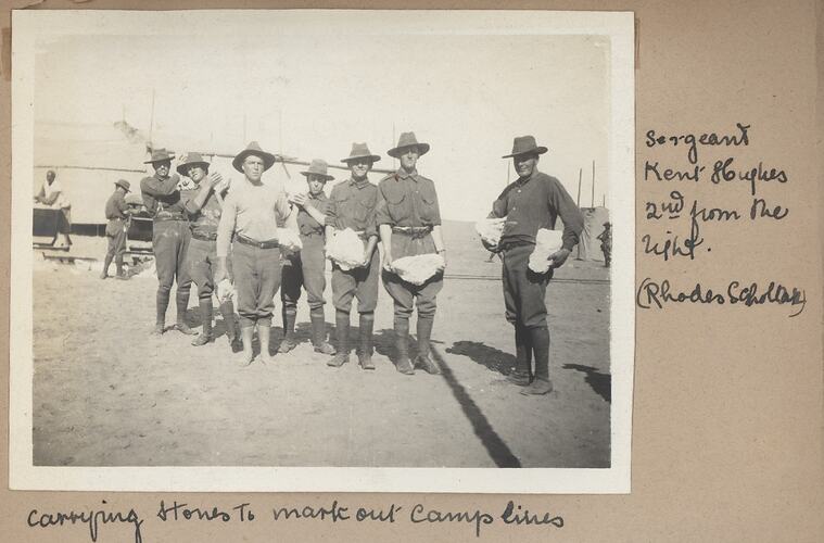 Group of servicemen carrying white stones.