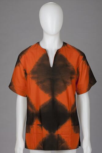 Mannequin wearing t-shirt: bright orange, black triangular patterned