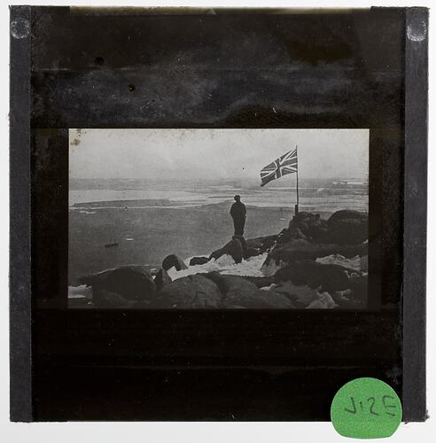 Lantern Slide - Explorer Planting the British Flag on Proclamation Island, BANZARE Voyage 1, Antarctica, 13 Jan 1930