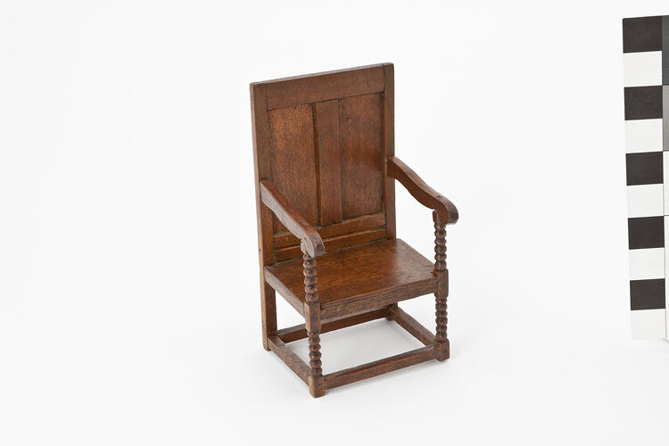 Wooden chair with arms and turned legs.