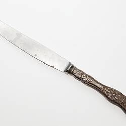 Knife with curved end, detail on handle.