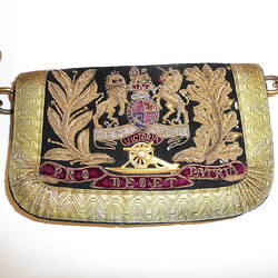 Black pouch attached to belt, fabric flap embroidered in gold with coat of arms above cannon and red banner.